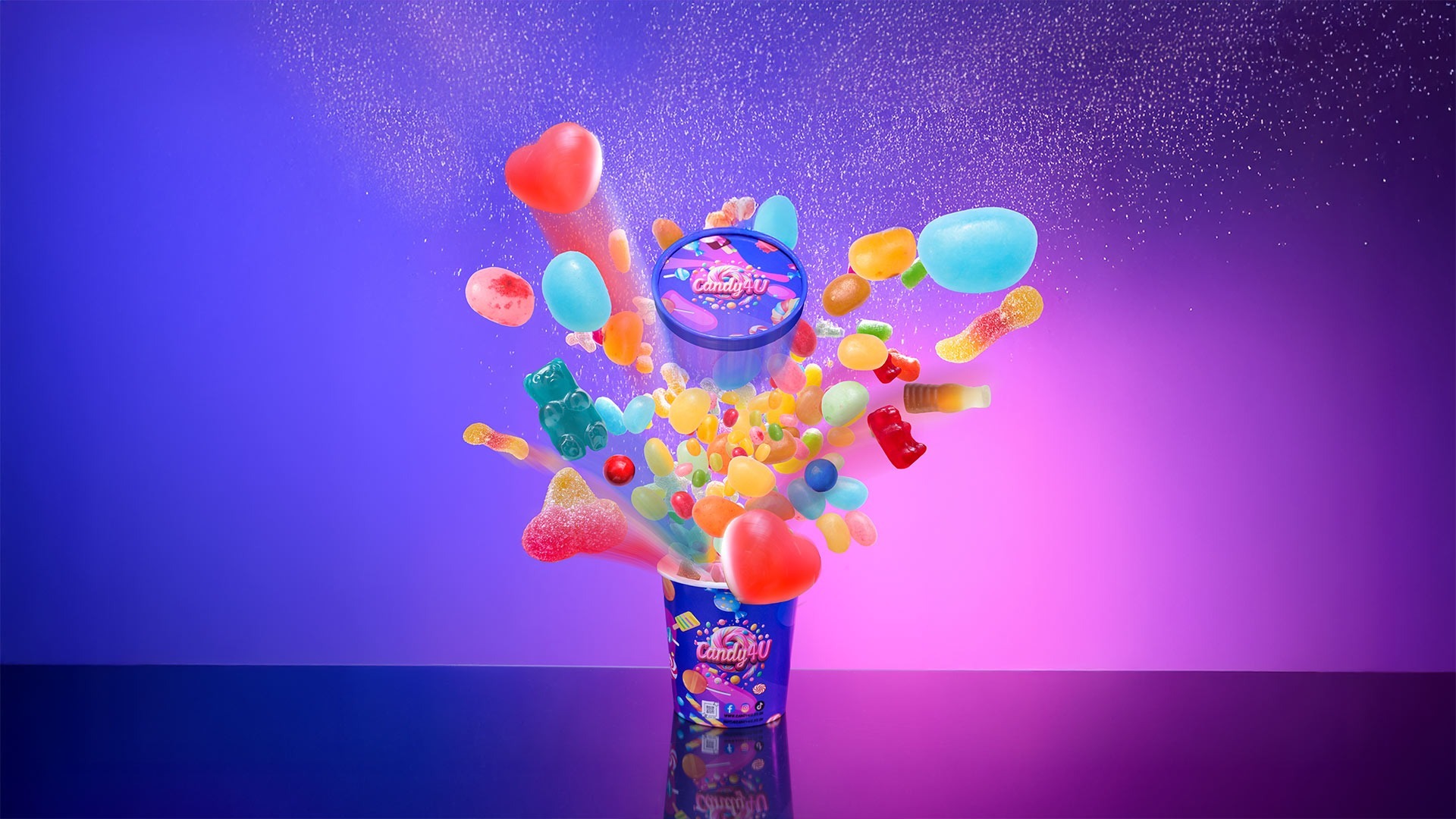 A tub of sweets frozen mid-explosion, with jelly beans, gummy bears and cola bottles flying upward in motion-blurred trails against a purple and magenta gradient backdrop.